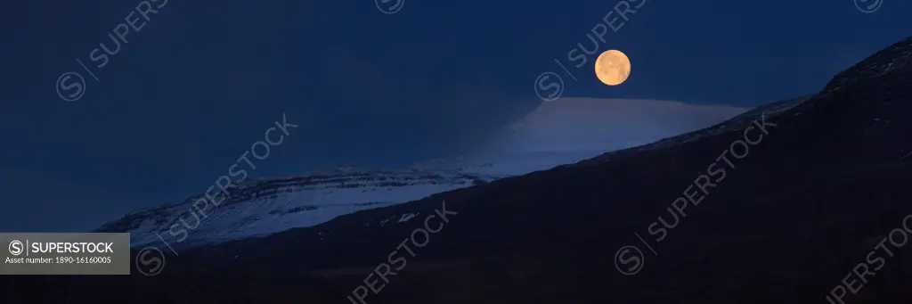 Panorama of full moon above snow covered mountains, Iceland, Polar Regions