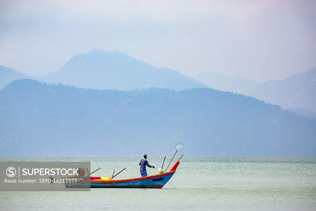 Fisherman on small boat, Strait of Malacca with Thai island of Ko Tarutao from Datai Bay Beach (Pantai Teluk Datai), Andaman Sea, Malaysia, Southeast Asia, Asia