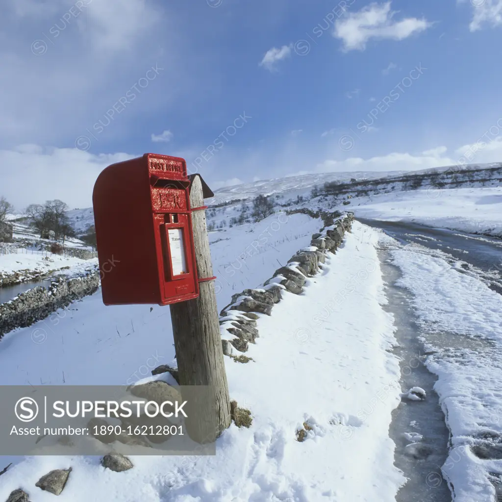 Traditional Red Postbox in a rural setting in the snow, North Yorkshire, England, United Kingdom, Europe