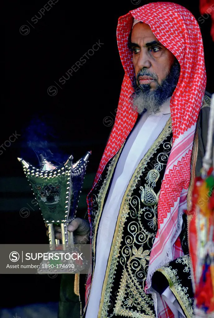 Bedouin man holding a smoking incense burner, Saudi Arabia