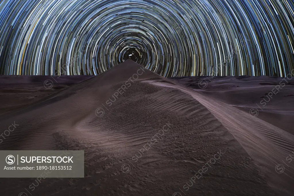 Concentric circumpolar star trail above sand dunes in the Rub al Khali desert, Oman, Middle East