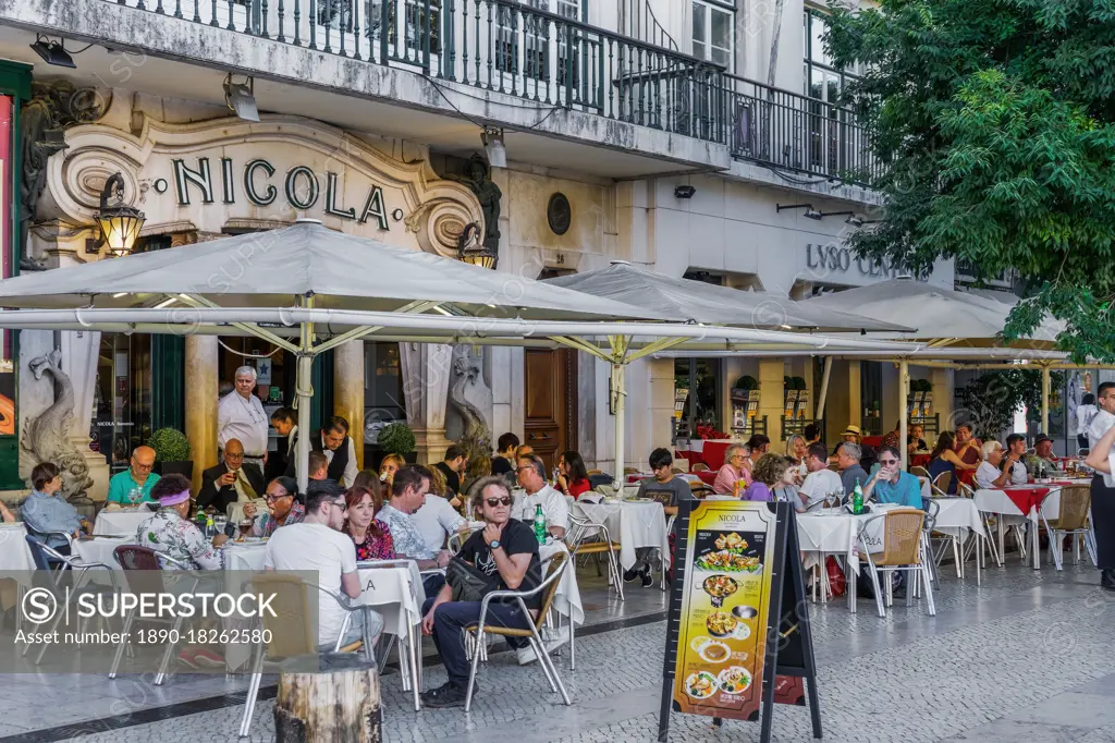 Historic Cafe Nicola entrance with art deco facade and seated customers at outdoor tables in Rossio Square, Lisbon, Portugal, Europe