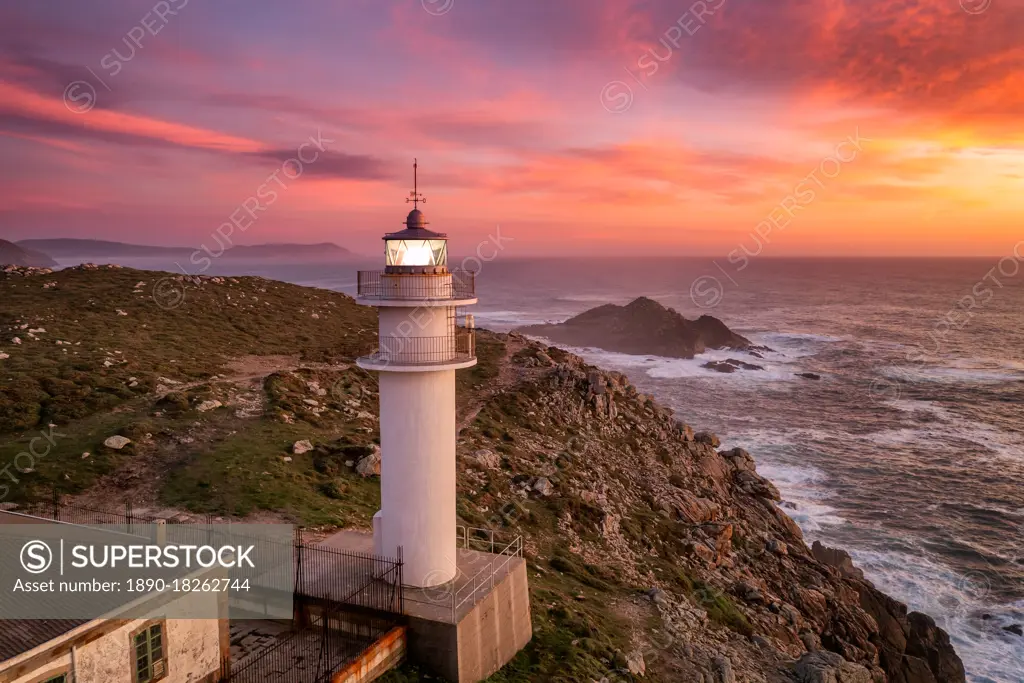 Aerial sea landscape view of Cape Tourinan Lighthouse at sunset with pink clouds, Galicia, Spain, Europe