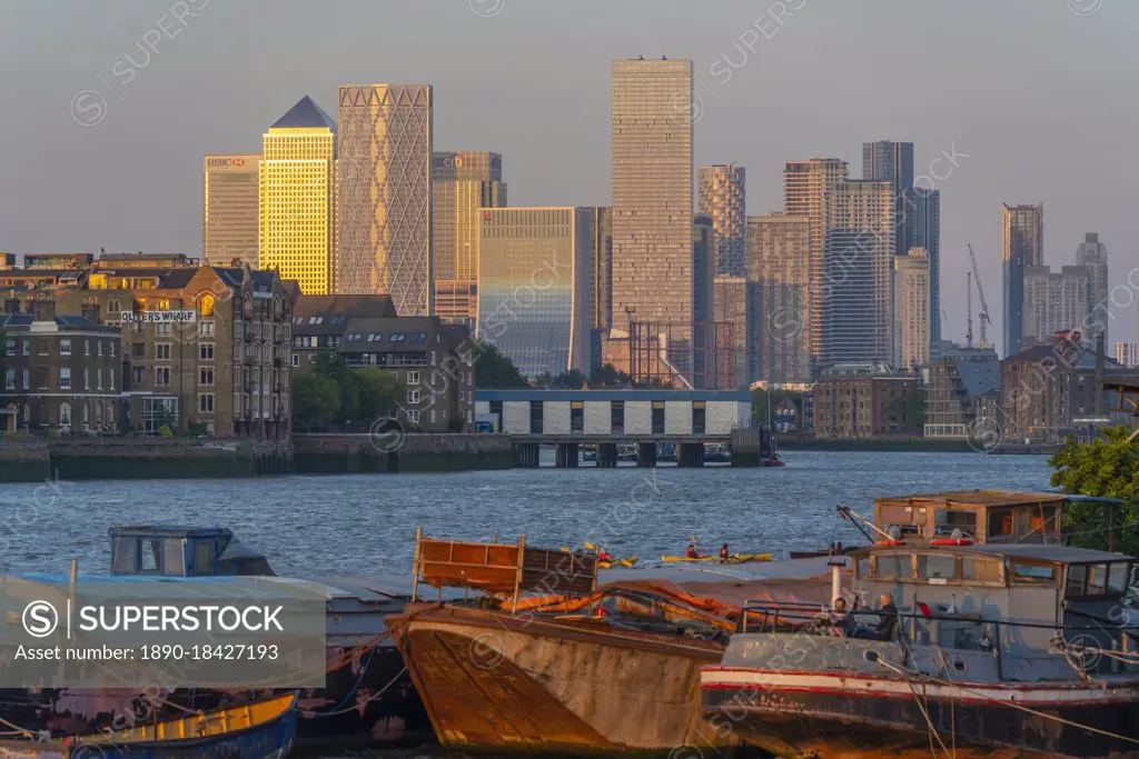 View of Thames barges, Docklands and Canary Wharf at sunset, London, England, United Kingdom, Europe