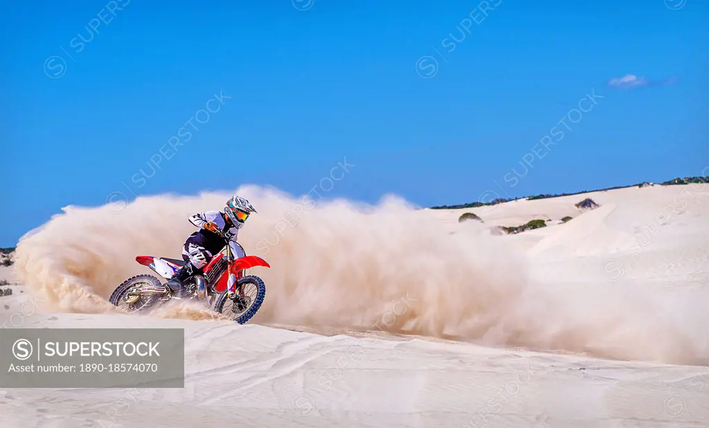 Trial bike rider kicking up sand at the sand dunes of Lancelin, Western Australia, Australia, Pacific