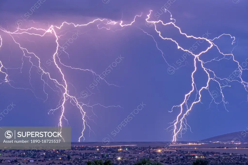 Lightning bolts striking Prescott area in the distance with the town of Chino Valley just north of Prescott Town in the foreground, Arizona, United States of America, North America