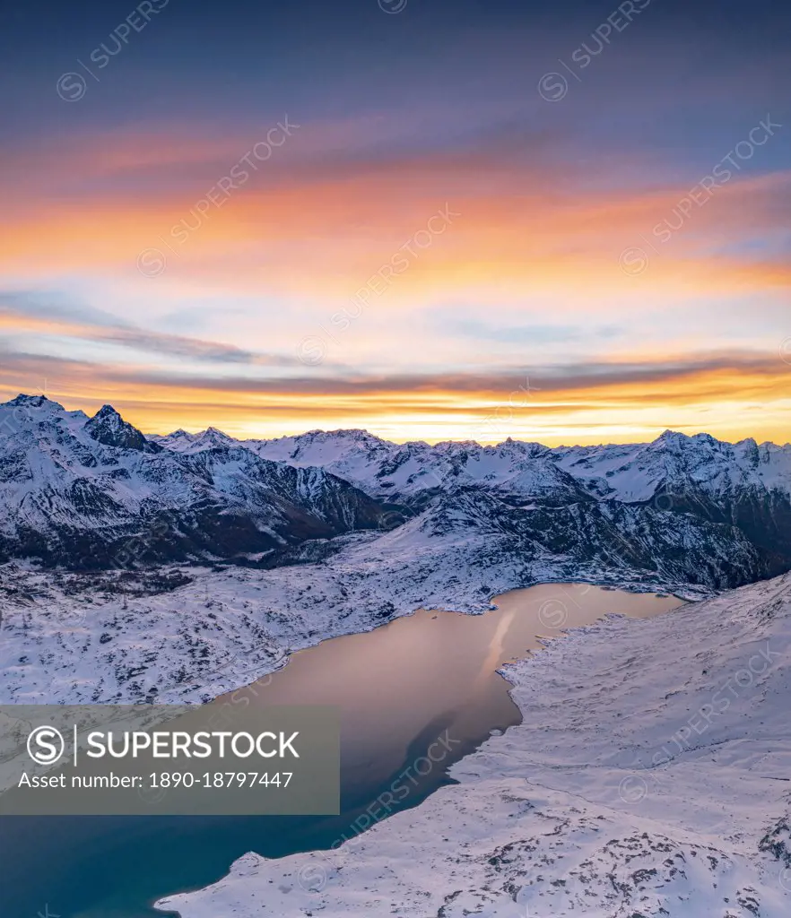 Aerial view of frozen lake Lago Bianco at Bernina mountain pass covered with snow at sunrise, Engadine, Graubunden, Switzerland, Europe