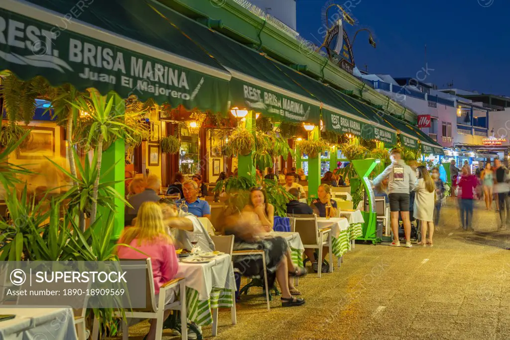 View of restaurants and shops overlooking Playa Blanca Beach at dusk, Playa Blanca, Lanzarote, Canary Islands, Spain, Atlantic, Europe