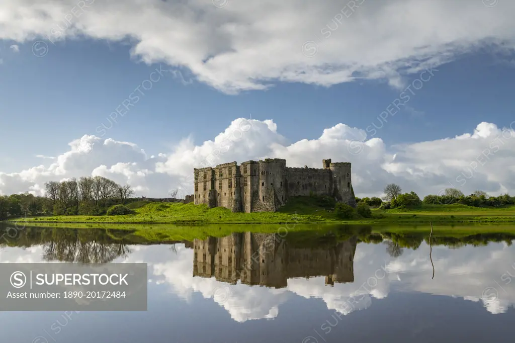 The magnificent ruins of Carew Castle reflected in the Mill Pond in spring, Carew, Pembrokeshire, Wales, United Kingdom, Europe