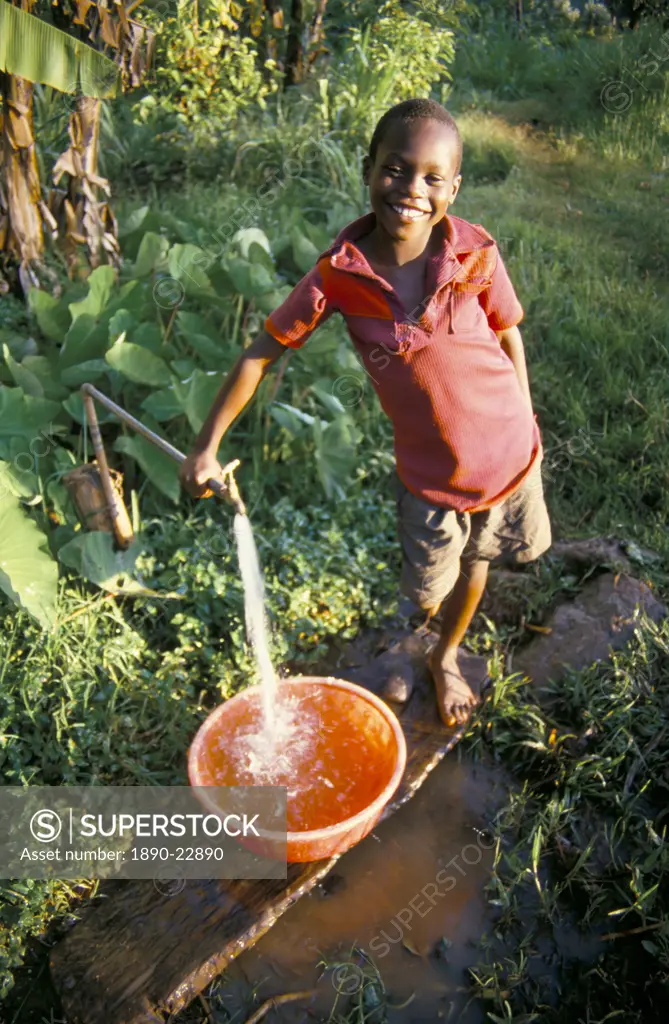 Boy at water tap, Chuka village, Mount Kenya, Kenya, East Africa, Africa