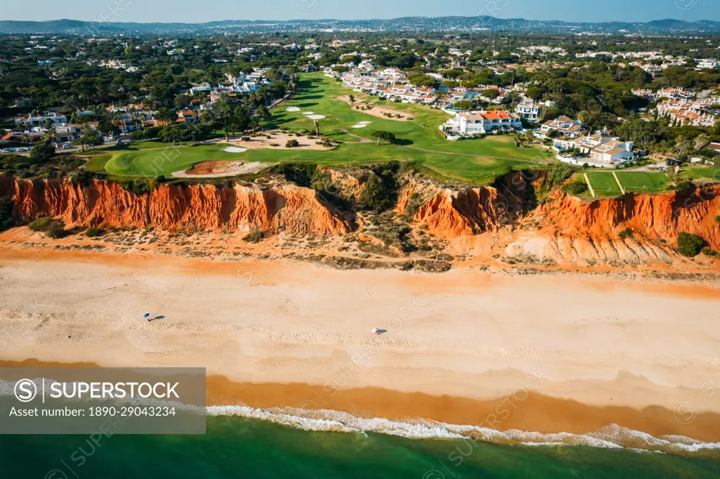 Aerial drone view of Praia de Vale do Lobo with magnificent golf courses overlooking the ocean in Algarve, Portugal, Europe