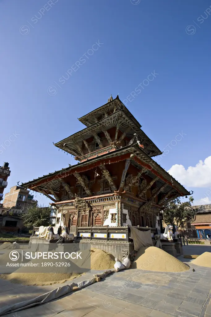 Piles of grain in front of the triple roofed pagoda of the Rato Machendranath temple, Patan, Kathmandu, Nepal, Asia