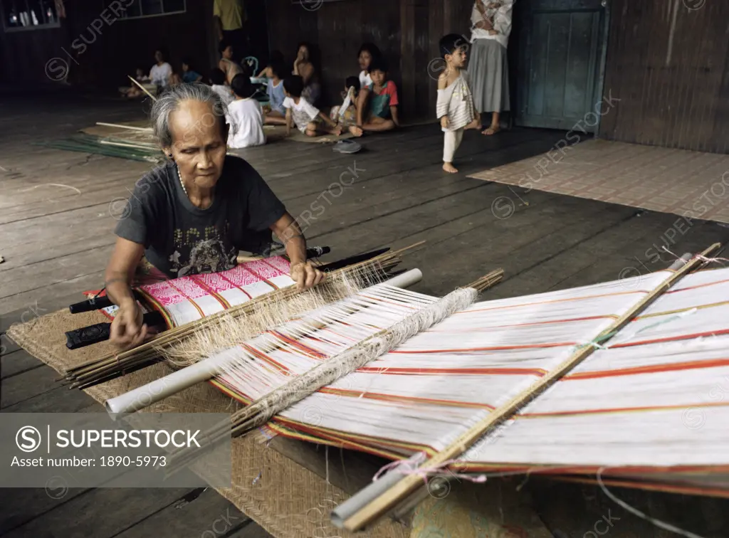 Iban woman weaving pua kumbu, in complex traditional patterns and reated to old head_hunting rituals, Katibas River, Sarawak, Malaysia, island of Born...