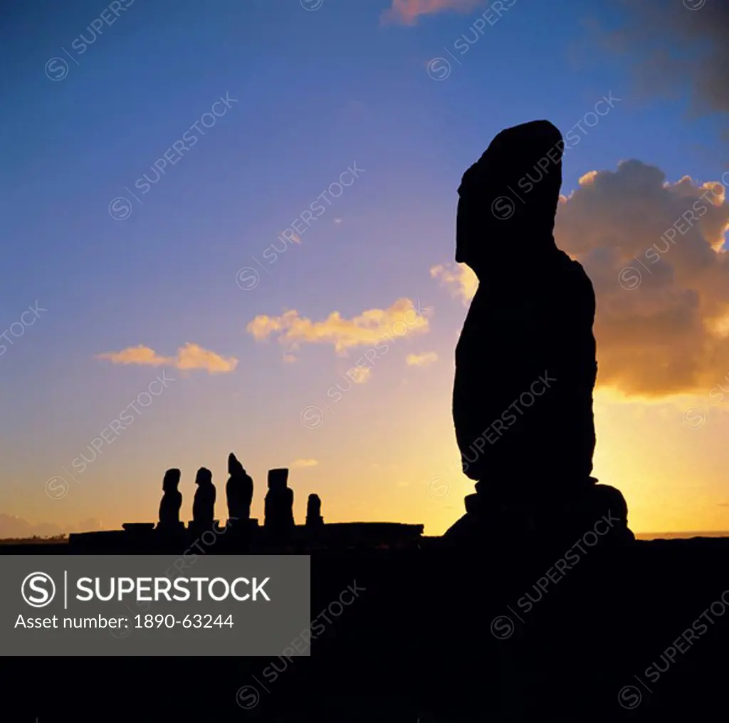 Silhouette of Ahu Tahai in foreground and behind the five moai statues of Ahu Vai Uri, Easter Island, Chile