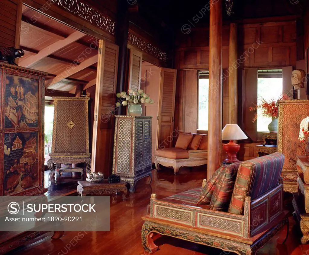 Traditional Thai house with old manuscript cabinet, table, and silk cushions in teak living room in Thailand, Southeast Asia, Asia