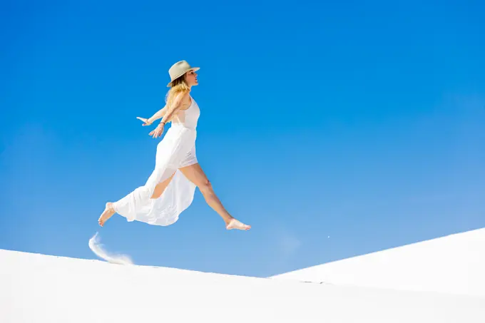 Woman jumping on the Gypsum Sand Dune, White Sands, New Mexico, United States of America, North America