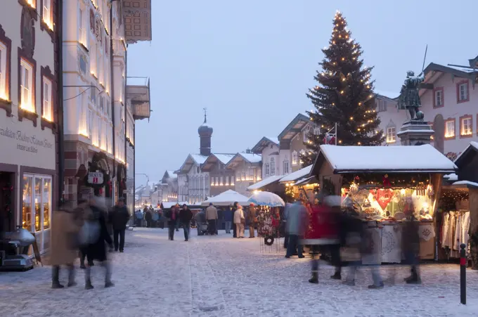 Christmas Market, Christmas tree with stalls and people at Marktstrasse at twilight in the spa town of Bad Tolz, Bavaria, Germany, Europe