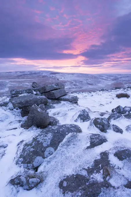 Beautiful sunrise in winter over a frozen snow covered moorland, Belstone Tor, Dartmoor, Devon, England, United Kingdom, Europe