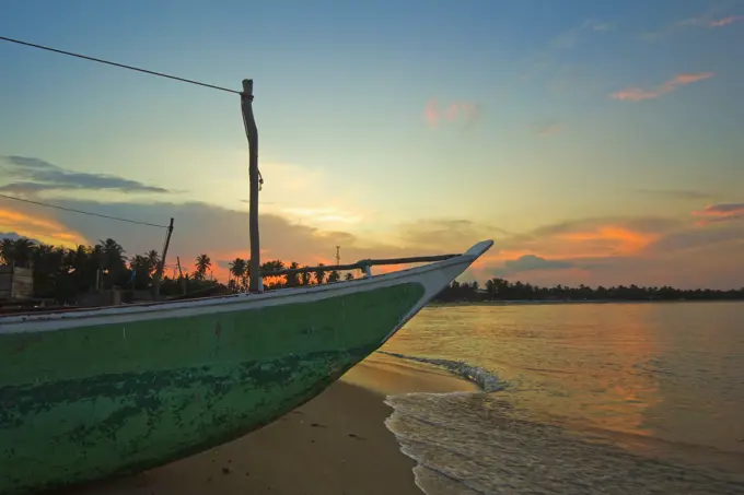 Outrigger boat at sunset at this fishing beach and popular tourist surf destination, Arugam Bay, Eastern Province, Sri Lanka, Asia