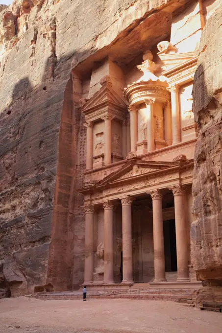 Tourist looking up at the facade of the Treasury Al Khazneh carved into the red rock at Petra, UNESCO World Heritage Site, Jordan, Middle East