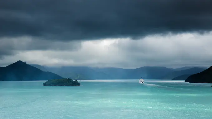 The narrow passageway of Queen Charlotte Sound with a ferry boat navigating its way through to the Cook Straits, Marlborough, South Island, New Zealan...