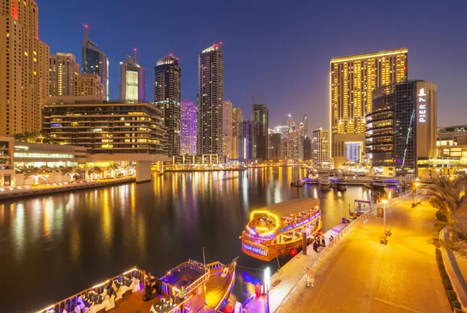 Dubai Marina skyline and tourist boats at night, Dubai City, United Arab Emirates, Middle East