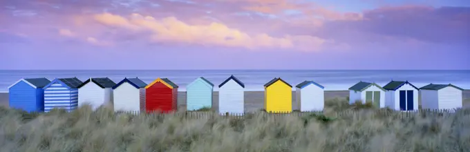 Colourful beach huts and sand dunes at sunset, Southwold, Suffolk, England, United Kingdom, Europe