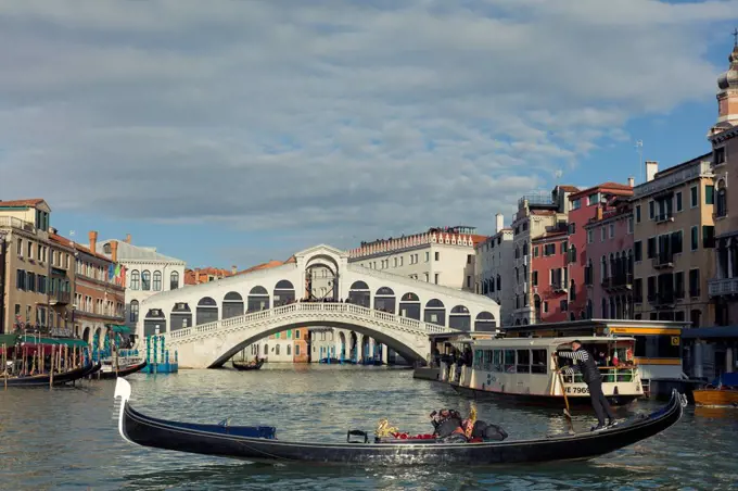 A gondola crossing the Grand Canal with a vaporetto and the Rialto Bridge beyond, Venice, UNESCO World Heritage Site, Veneto, Italy, Europe