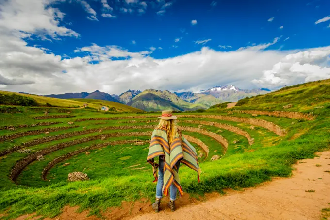 Woman looking out at Inca ruins, Moray, Peru, South America