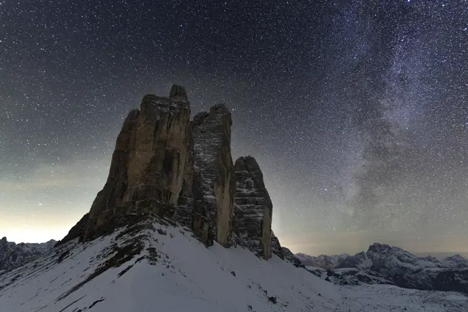 Stars in the night sky over the majestic rocks of Tre Cime di Lavaredo, Sesto Dolomites, South Tyrol, Italy, Europe