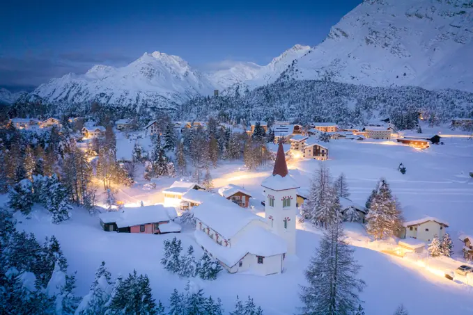 Dusk over Chiesa Bianca and Maloja village covered with snow, Bregaglia, Engadine, Graubunden Canton, Switzerland, Europe