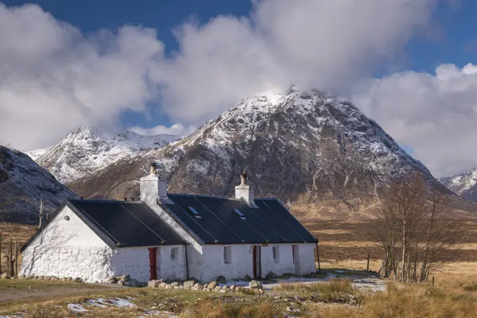 Black Rock Cottage bothy on Rannoch Moor with a snow dusted Buachaille Etive Mor looming behind in winter, Highlands, Scotland, United Kingdom, Europe