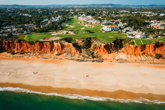 Aerial drone view of Praia de Vale do Lobo with magnificent golf courses overlooking the ocean in Algarve, Portugal, Europe