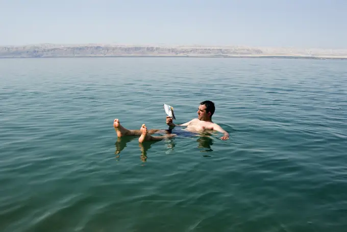 Tourist reading a book, Dead Sea, Jordan, Middle East