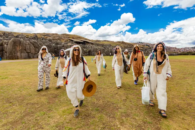 Women dressed in alpaca llama onesies in Cusco, Peru, South America