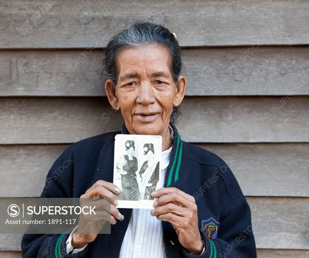 Woman holding a photograph of herself, Myanmar