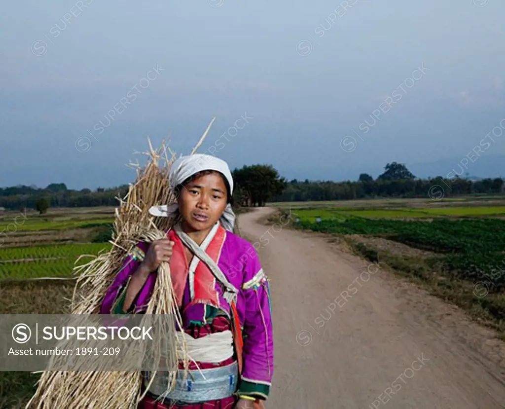 Ang Woman carrying a bundle of straw, Myanmar