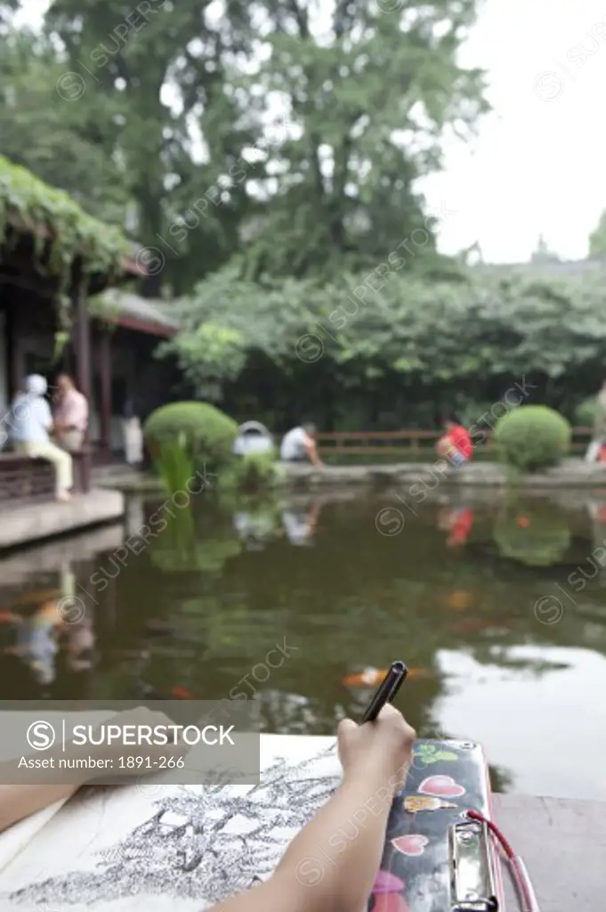 Artist drawing a picture at the lakeside, Chengdu, Sichuan Province, China