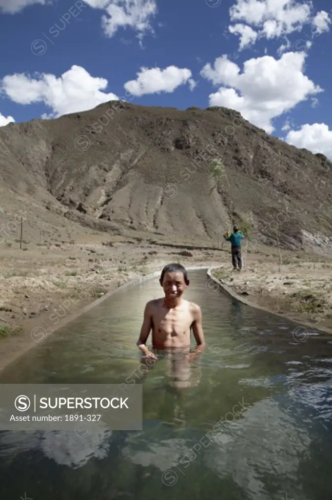 Boy taking bath in a Creek, Tibet,