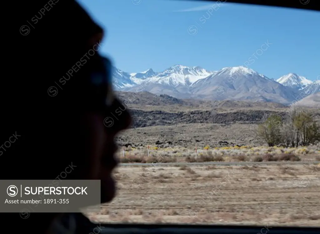 Silhouette of a person's face with mountain range in the background