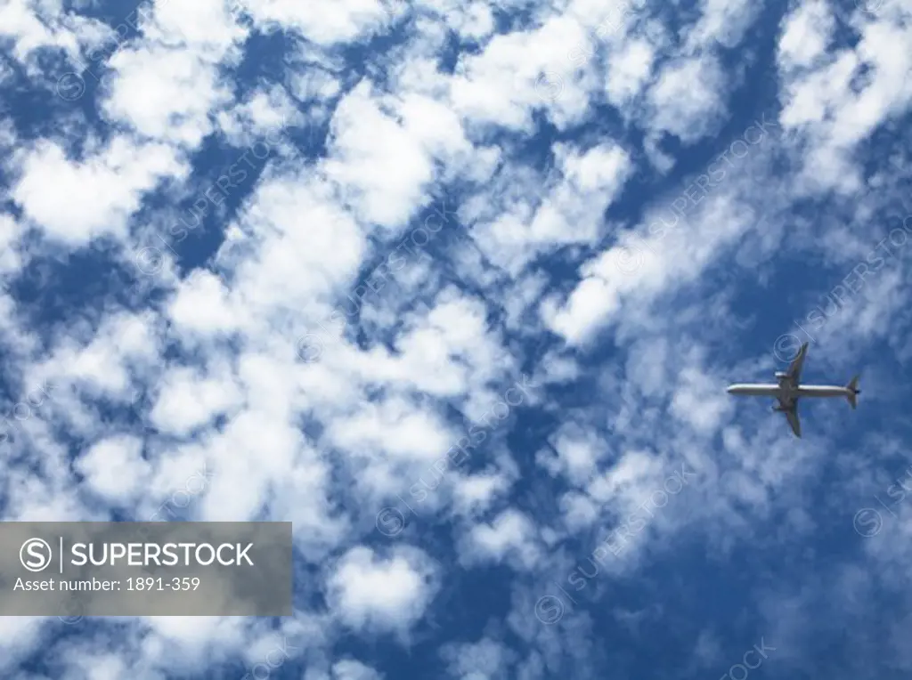 Airplane in flight against the cloudy sky