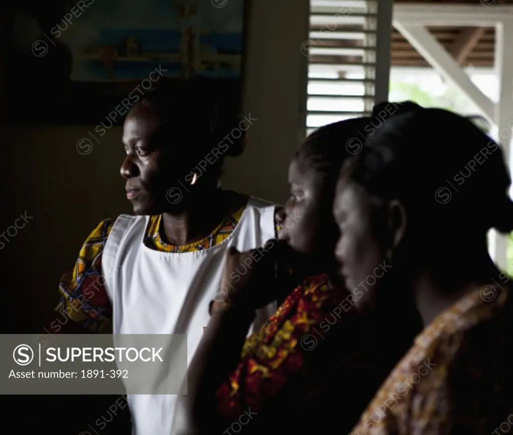 Three women looking through a window, Jamaica