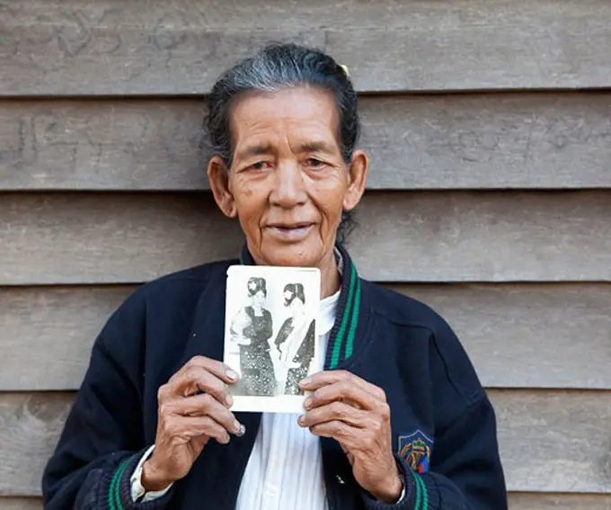 Woman holding a photograph of herself, Myanmar