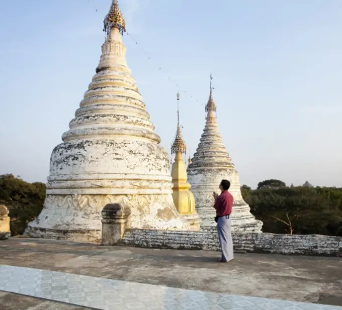 Man praying in front of a temple, Myanmar