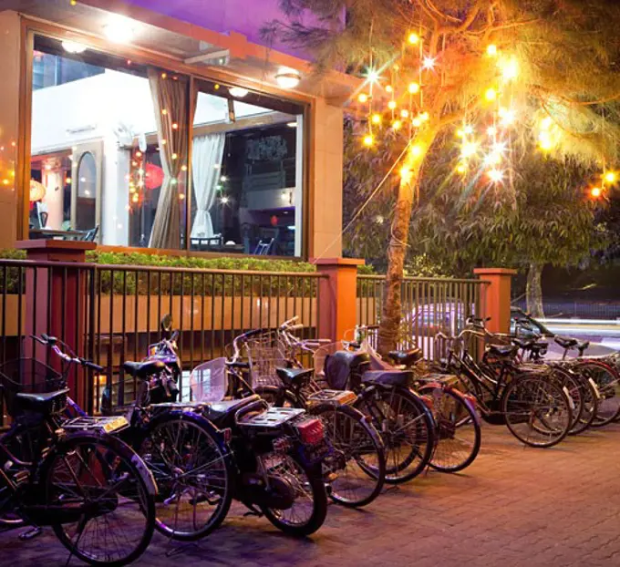 Bicycles parked under a lit up tree, Mandalay, Myanmar