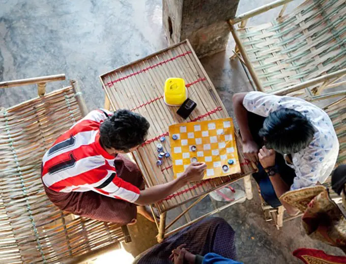 Teenage boys playing chess, Myanmar