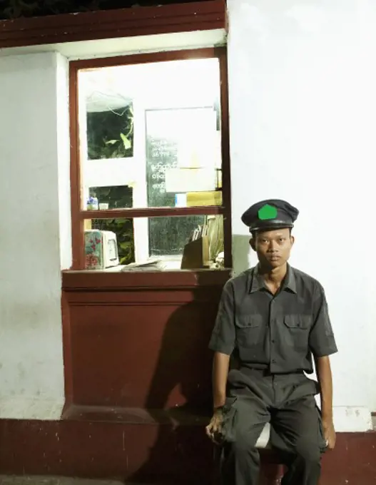 Security guard sitting outside a store, Myanmar