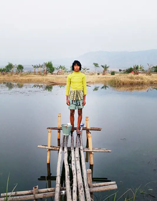 Boy standing on a pier, Myanmar