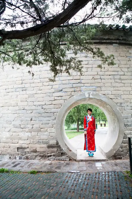 Woman standing at the circular entrance of a park, Forbidden City, Beijing, China