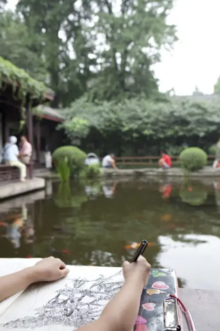 Artist drawing a picture at the lakeside, Chengdu, Sichuan Province, China